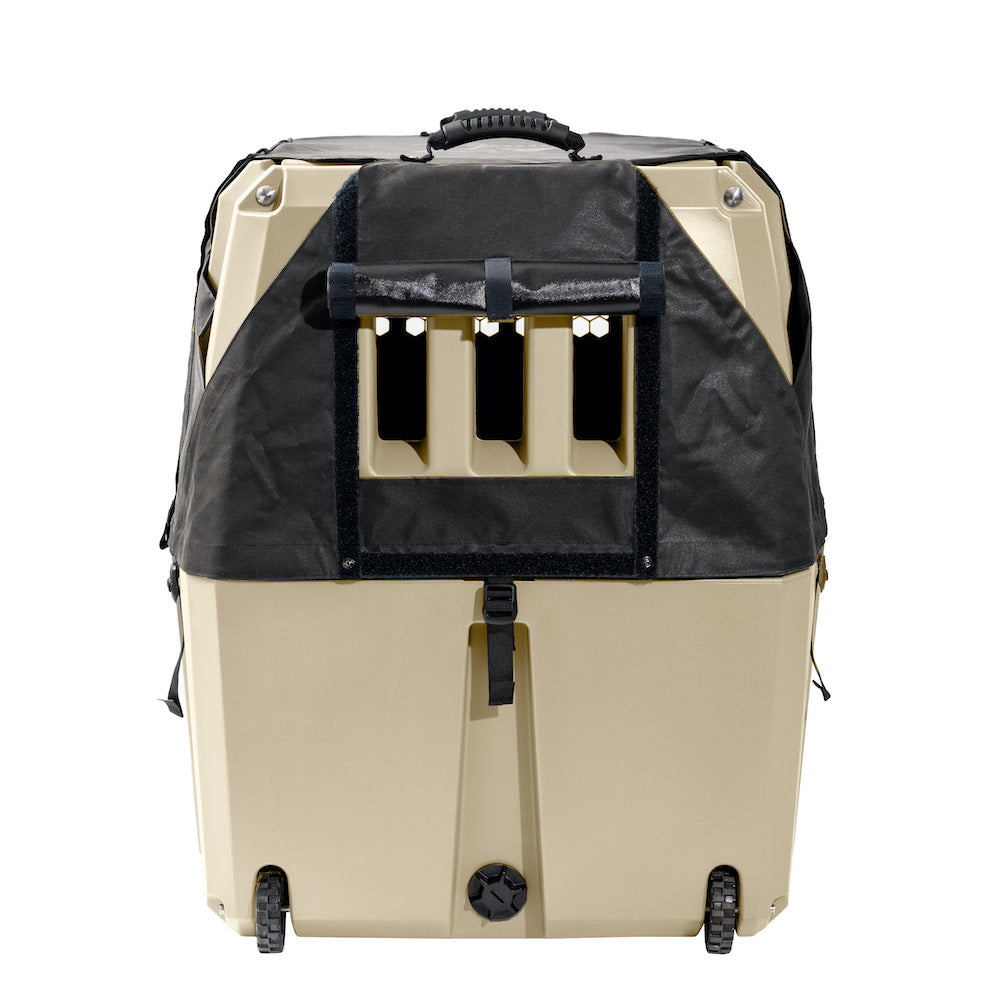 The GUNNER ALL-WEATHER KIT 2.0 is a beige and black hard-shell pet carrier with ventilation slots, a top handle, bottom wheels, and a black UV-protective fabric cover that partially encloses the upper section.