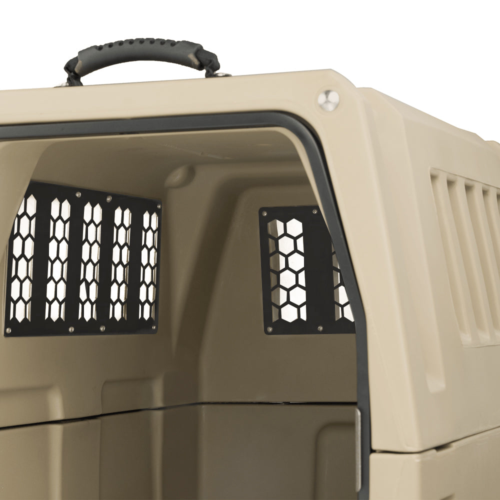 A close-up of the CHEW KIT by GUNNER—a beige plastic pet crate with hexagonal ventilation windows, a black handle on top, and a visible interior and open door—showcasing premium dog kennel protection.