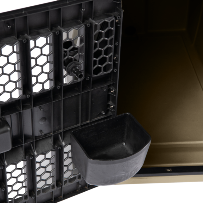 A close-up of a black crate door with a honeycomb pattern features an attached rectangular KENNEL BOWL, perfect for dog hydration, partially revealing the crate’s interior.